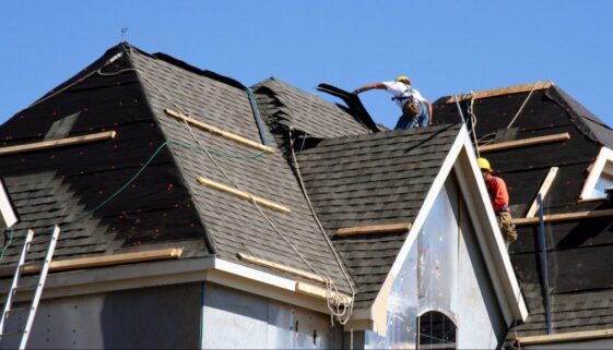 Roof Workers on top of house with blue sky