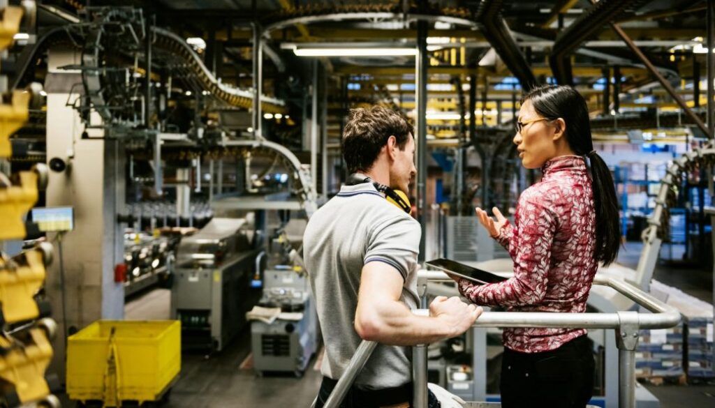Mechanic And Female Engineer Talking in Factory