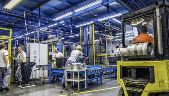 Forklift and manual workers in a factory