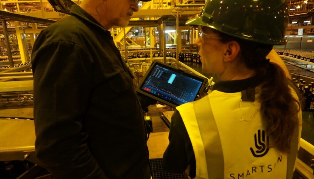 A line supervisor and a Smart Skin employee review data gathered from a beverage production line. (Image: SST)